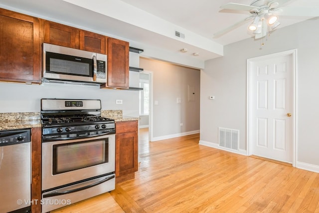 4449 W Sunnyside Ave Unit 2, Chicago, IL 60630 - kitchen featuring stainless steel appliances, light wood-style floors, ceiling fan, and light stone countertops