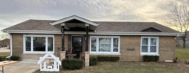 view of front of house featuring brick siding and a shingled roof