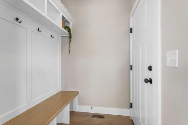 mudroom featuring visible vents, baseboards, and dark wood-style floors