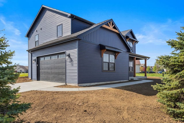 view of side of property with a shingled roof, an attached garage, and concrete driveway