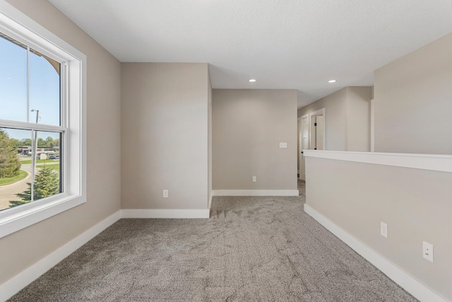 carpeted spare room featuring recessed lighting and baseboards