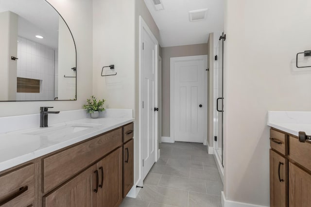 bathroom with tile patterned flooring, vanity, baseboards, visible vents, and a stall shower