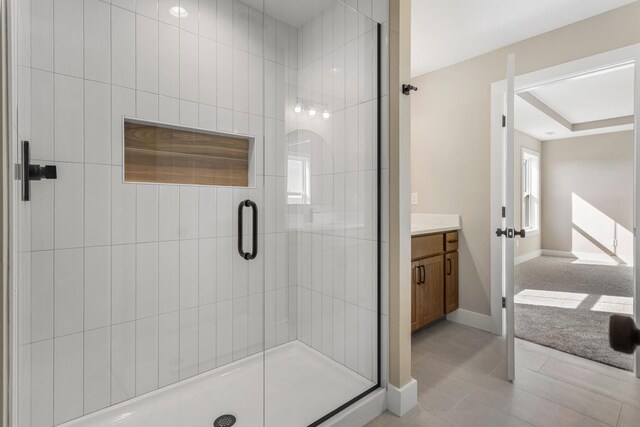 full bathroom featuring vanity, baseboards, a shower stall, and tile patterned flooring