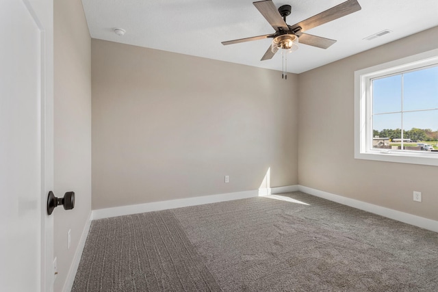spare room featuring visible vents, carpet, ceiling fan, and baseboards