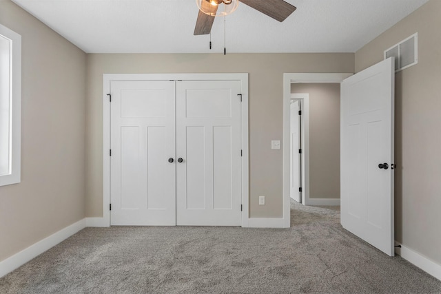 unfurnished bedroom featuring baseboards, carpet, and visible vents