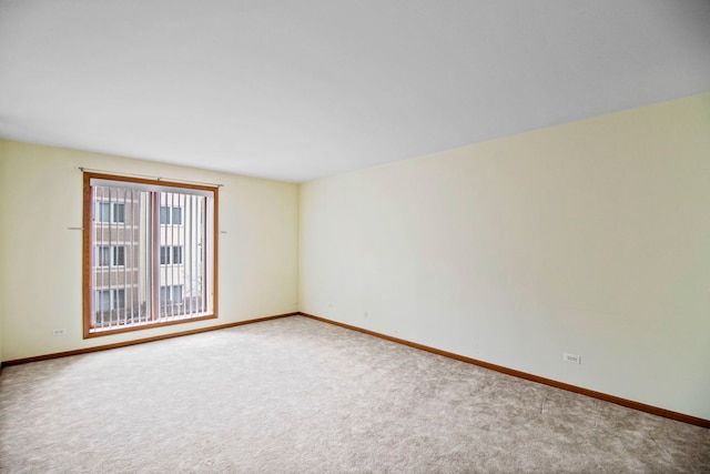 carpeted empty room with baseboards
