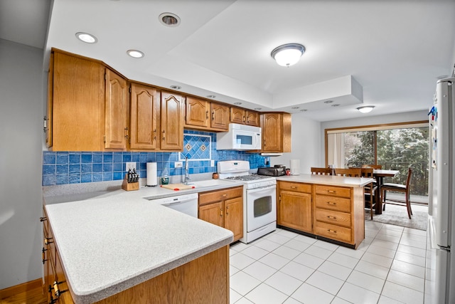 kitchen featuring a peninsula, light tile patterned flooring, backsplash, white appliances, and light countertops