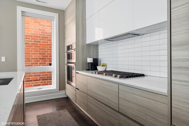 1448 W Chestnut St Unit 2, Chicago, IL 60642 - kitchen with decorative backsplash, visible vents, modern cabinets, stainless steel appliances, and white cabinetry