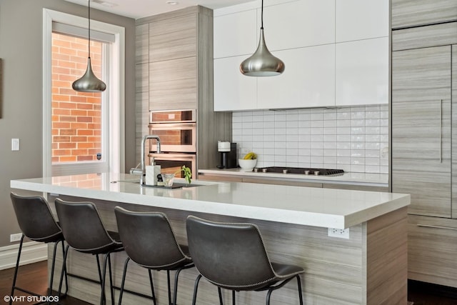 1448 W Chestnut St Unit 2, Chicago, IL 60642 - kitchen featuring stainless steel double oven, gas stovetop, modern cabinets, and a breakfast bar
