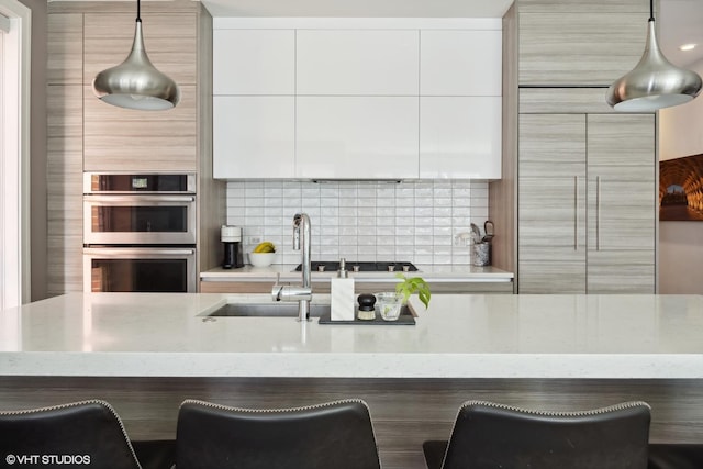 1448 W Chestnut St Unit 2, Chicago, IL 60642 - kitchen with double oven, decorative backsplash, modern cabinets, and light stone counters