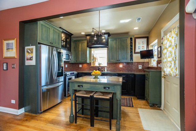 4432 N Racine Ave Unit 3S, Chicago, IL 60640 - kitchen featuring light wood finished floors, a kitchen bar, open shelves, tasteful backsplash, and appliances with stainless steel finishes