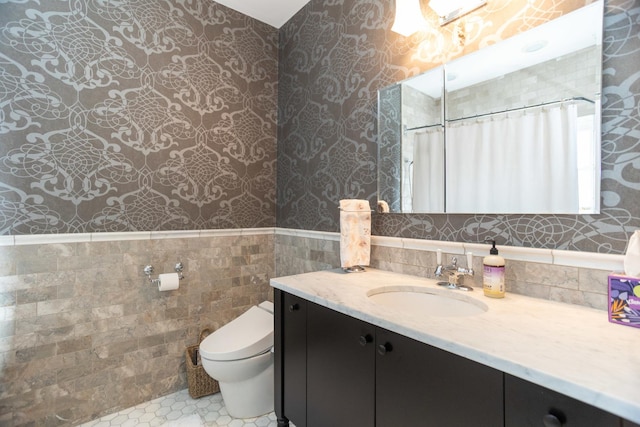 4432 N Racine Ave Unit 3S, Chicago, IL 60640 - bathroom with toilet, wallpapered walls, tile walls, wainscoting, and vanity