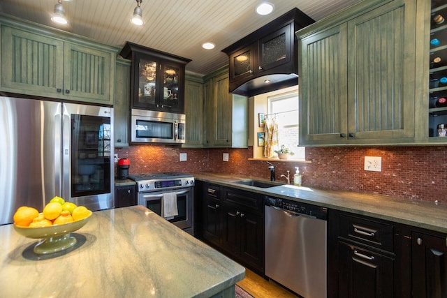 4432 N Racine Ave Unit 3S, Chicago, IL 60640 - kitchen with glass insert cabinets, a sink, green cabinetry, appliances with stainless steel finishes, and decorative backsplash