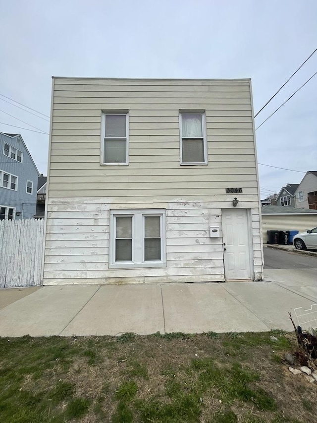 rear view of house with a patio area and fence