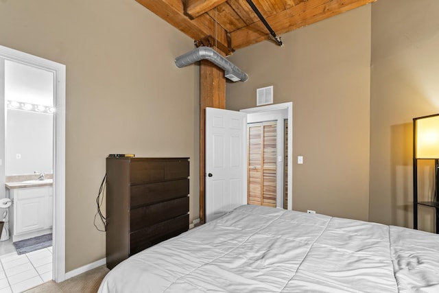 1740 N Maplewood Ave Unit 102, Chicago, IL 60647 - tiled bedroom featuring baseboards, visible vents, beamed ceiling, wooden ceiling, and ensuite bath