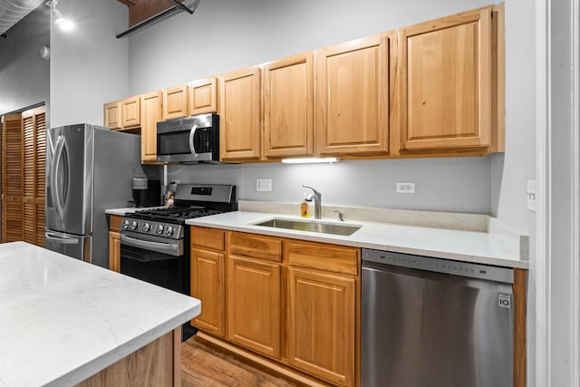 1740 N Maplewood Ave Unit 102, Chicago, IL 60647 - kitchen featuring wood finished floors, a sink, appliances with stainless steel finishes, and light stone counters