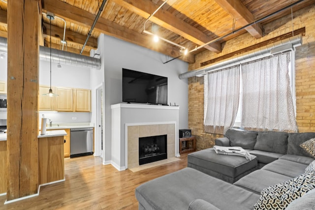 1740 N Maplewood Ave Unit 102, Chicago, IL 60647 - living area featuring light wood-type flooring, beam ceiling, wood ceiling, a fireplace, and brick wall