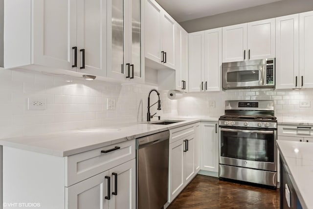 2259 W Wabansia Ave Unit 309, Chicago, IL 60647 - kitchen featuring appliances with stainless steel finishes, a sink, tasteful backsplash, and white cabinets