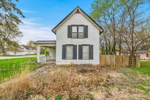 back of house featuring a porch and fence