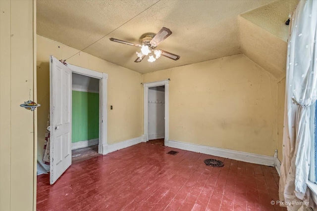bonus room with lofted ceiling, a textured ceiling, ceiling fan, visible vents, and wood finished floors