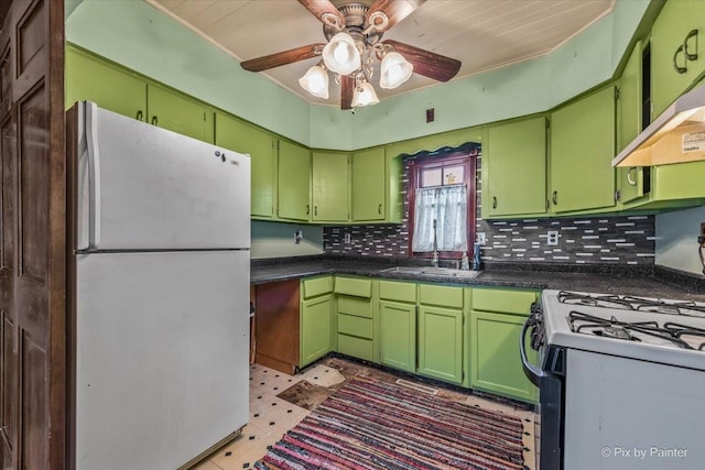 kitchen with a sink, ceiling fan, backsplash, freestanding refrigerator, and gas range