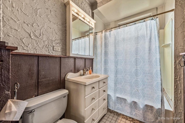bathroom featuring vanity, shower / bath combo with shower curtain, toilet, and tile patterned flooring