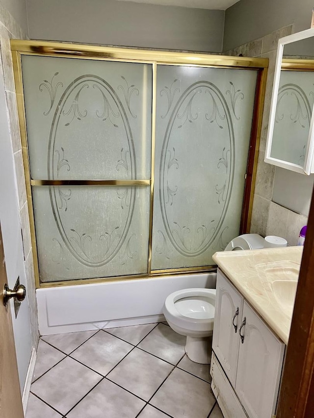 full bath featuring toilet, vanity, tile patterned floors, and shower / bath combination with glass door