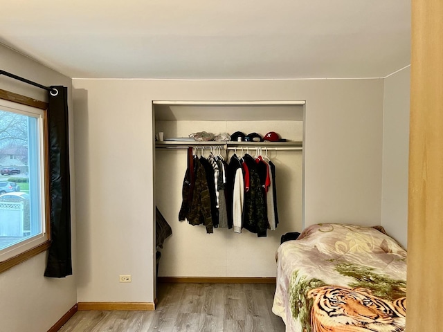 bedroom featuring wood finished floors, a closet, and baseboards