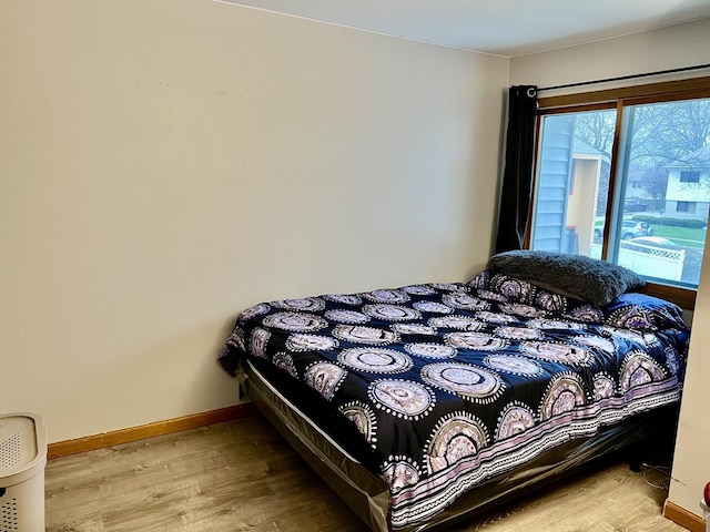 bedroom featuring wood finished floors and baseboards