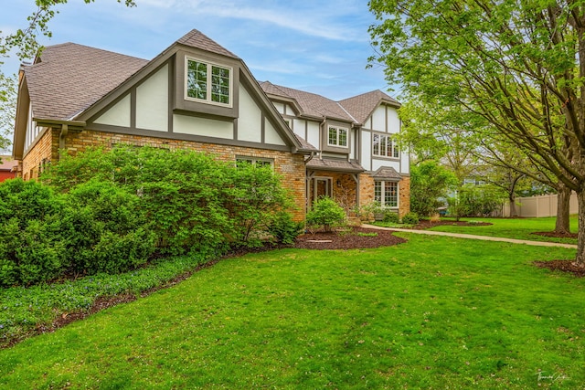 5930 Hillcrest Ct, Downers Grove, IL 60516 - tudor house with fence, a front yard, roof with shingles, stucco siding, and brick siding