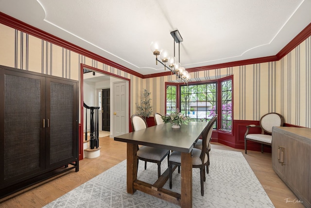 5930 Hillcrest Ct, Downers Grove, IL 60516 - dining room featuring an inviting chandelier, wainscoting, light wood-style floors, wallpapered walls, and ornamental molding
