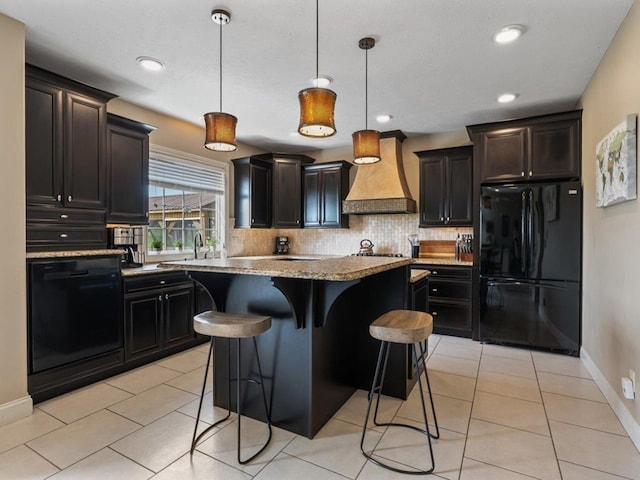 kitchen featuring premium range hood, a center island, baseboards, decorative backsplash, and black appliances