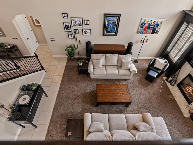 tiled living room featuring baseboards and arched walkways