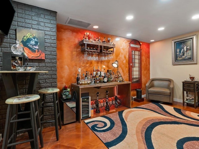bar featuring recessed lighting, baseboards, visible vents, and a bar