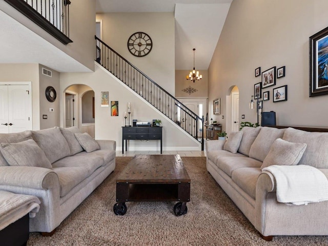 carpeted living room featuring arched walkways, a high ceiling, and stairs