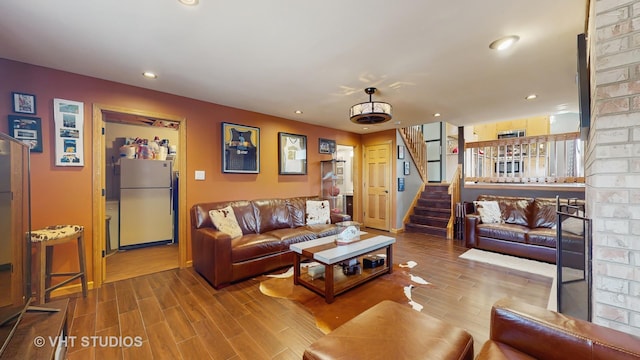 living room featuring recessed lighting, wood finished floors, and stairway