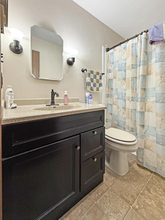 bathroom with a shower with curtain, tile patterned floors, vanity, and toilet