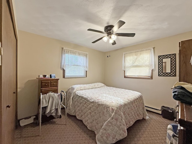 carpeted bedroom featuring a baseboard radiator, ceiling fan, and multiple windows
