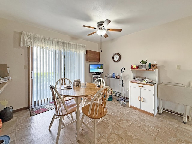 dining room with a baseboard heating unit, baseboards, and a ceiling fan