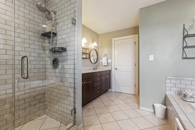 full bathroom with a shower stall, baseboards, vanity, and tile patterned floors