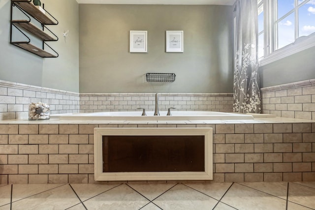 bathroom with tile walls, tile patterned floors, a garden tub, and a wainscoted wall