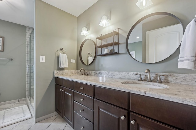 full bathroom with double vanity, tile patterned floors, a stall shower, and a sink