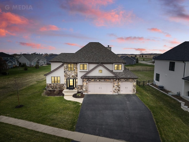 view of front facade with a chimney, aphalt driveway, fence, stone siding, and a front yard