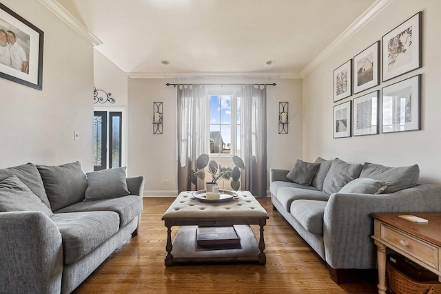 living area with baseboards, wood finished floors, and crown molding