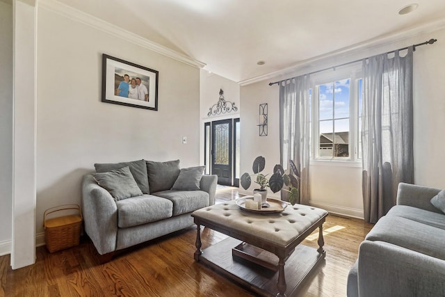 living area with wood finished floors, baseboards, a wealth of natural light, and crown molding