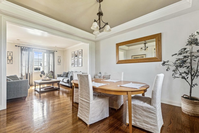 dining space featuring baseboards, crown molding, a tray ceiling, and dark wood-style floors