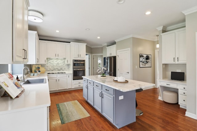 kitchen with white cabinetry, freestanding refrigerator, and a sink