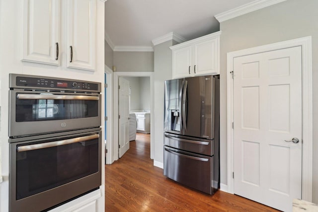 kitchen with dark wood-type flooring, white cabinetry, stainless steel appliances, and crown molding