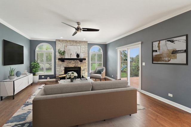 living room with a fireplace, a healthy amount of sunlight, a ceiling fan, and baseboards