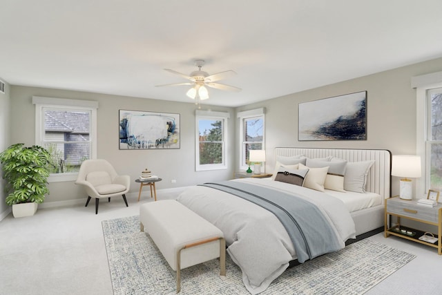 carpeted bedroom with multiple windows, ceiling fan, and baseboards